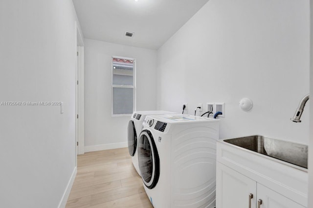 3527 Forest View Cir, Dania Beach, FL 33312 - laundry area with a sink, washer and clothes dryer, light wood-type flooring, baseboards, and visible vents