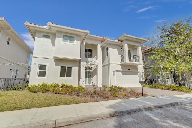 3527 Forest View Cir, Dania Beach, FL 33312 - view of front facade featuring a balcony, driveway, an attached garage, fence, and stucco siding
