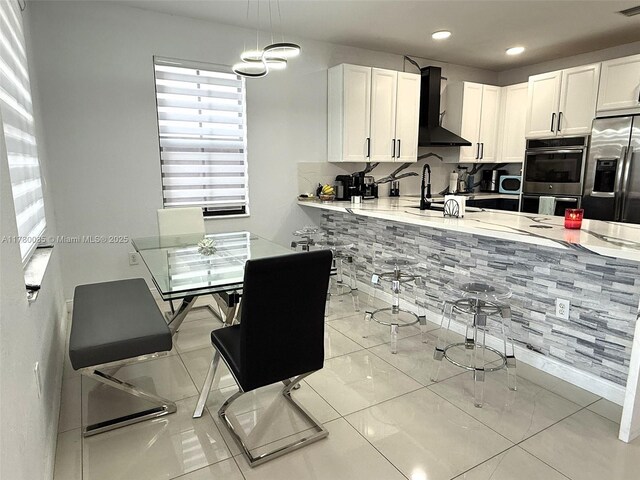 10060 NW 86th Ter, Doral, FL 33178 - kitchen featuring wall chimney exhaust hood, appliances with stainless steel finishes, white cabinetry, light countertops, and recessed lighting