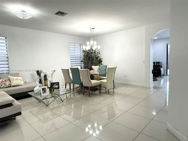 10060 NW 86th Ter, Doral, FL 33178 - dining area featuring arched walkways, a chandelier, baseboards, and light tile patterned flooring