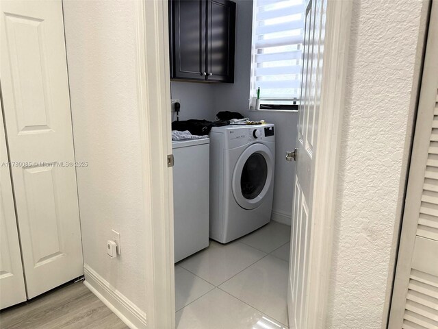 10060 NW 86th Ter, Doral, FL 33178 - washroom with a textured wall, independent washer and dryer, cabinet space, light tile patterned flooring, and baseboards