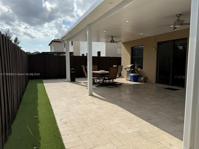 10060 NW 86th Ter, Doral, FL 33178 - fenced backyard with a ceiling fan, outdoor dining area, a patio, and area for grilling