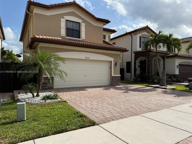 10060 NW 86th Ter, Doral, FL 33178 - mediterranean / spanish-style house with decorative driveway, stucco siding, an attached garage, and a tiled roof