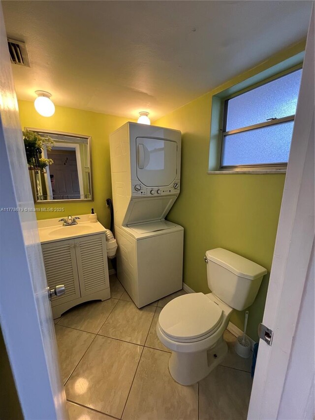18555 NE 14th Ave Unit 516, Miami, FL 33179 - half bath featuring vanity, stacked washer and clothes dryer, tile patterned flooring, toilet, and visible vents
