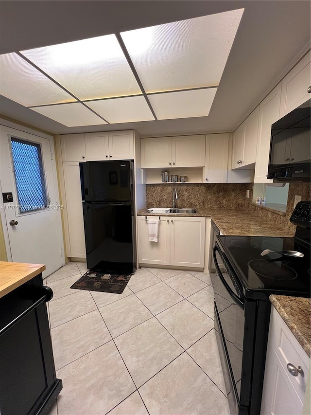 18555 NE 14th Ave Unit 516, Miami, FL 33179 - kitchen featuring tasteful backsplash, white cabinets, a sink, black appliances, and light tile patterned flooring