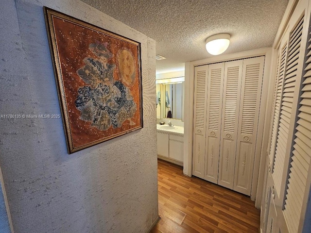 18061 Biscayne Blvd Unit 802, Aventura, FL 33160 - corridor with a sink, wood finished floors, and a textured ceiling