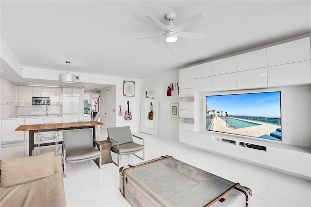 living area with a ceiling fan and light tile patterned flooring