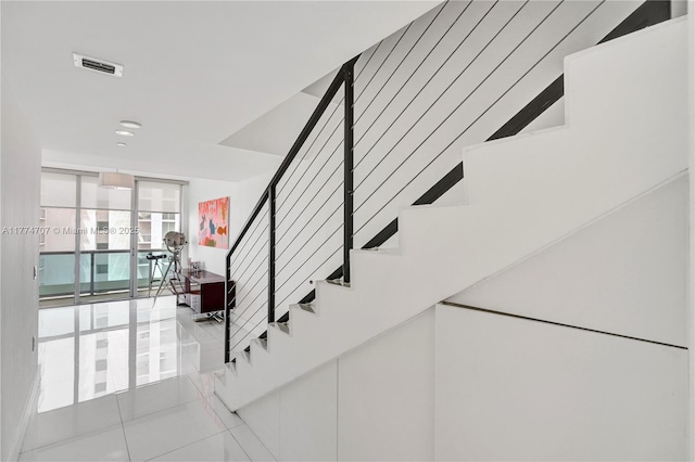 stairway with recessed lighting, tile patterned floors, visible vents, and a wall of windows