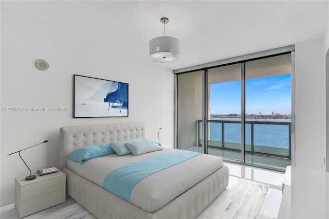 bedroom with access to exterior, floor to ceiling windows, and a water view
