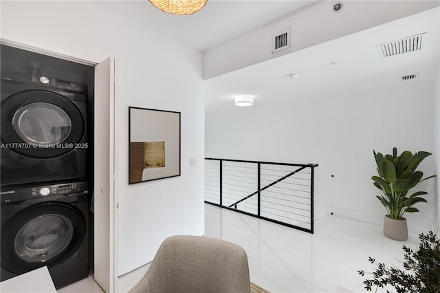 laundry room featuring stacked washer / dryer, laundry area, and visible vents