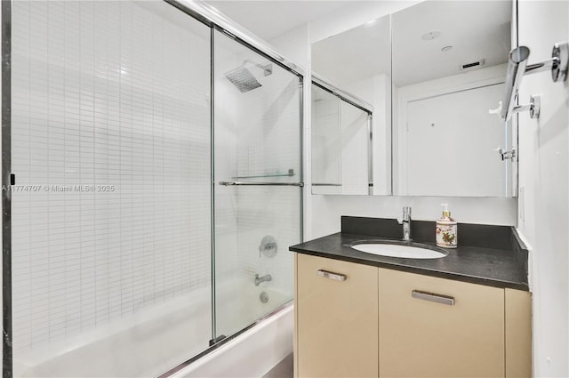 full bath featuring vanity and bath / shower combo with glass door