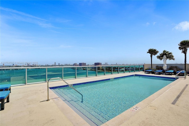 community pool with a patio and a view of city