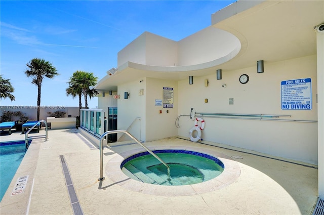 view of pool with a patio, a community hot tub, and a pool