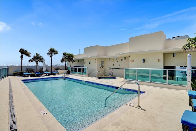 community pool with a patio area and a community hot tub