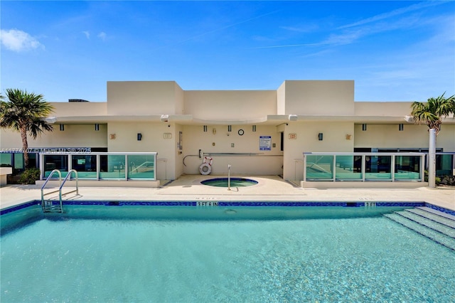 pool with a patio and a hot tub