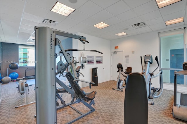 exercise room featuring visible vents, baseboards, a drop ceiling, and carpet