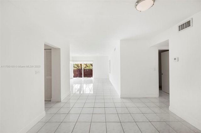 empty room featuring visible vents, baseboards, and light tile patterned floors