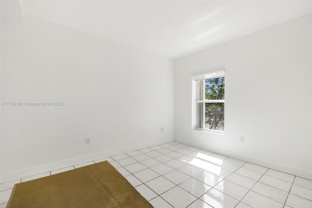 unfurnished room featuring baseboards and light tile patterned flooring