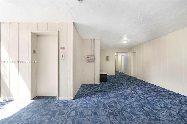 interior space with elevator, carpet floors, and a textured ceiling