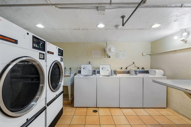 community laundry room featuring light tile patterned floors and washing machine and dryer