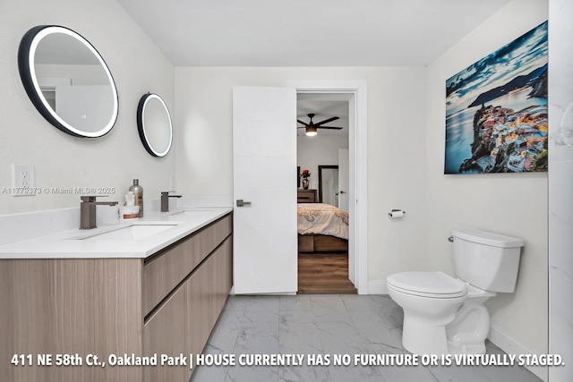 411 NE 58th Ct, Oakland Park, FL 33334 - ensuite bathroom featuring toilet, ensuite bathroom, ceiling fan, marble finish floor, and vanity