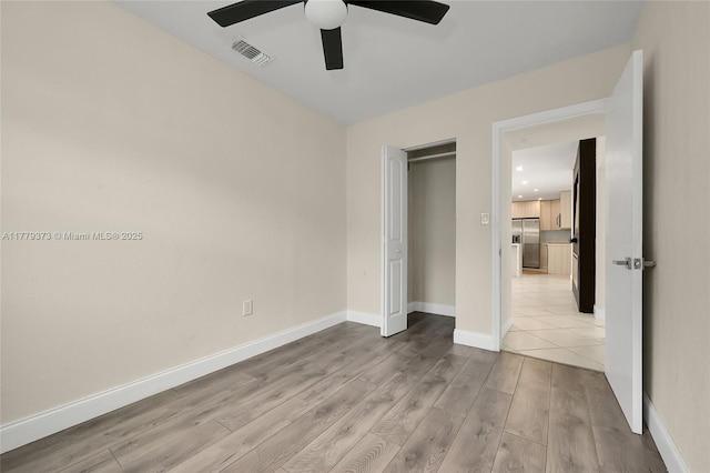 411 NE 58th Ct, Oakland Park, FL 33334 - unfurnished bedroom featuring light wood-style flooring, a ceiling fan, stainless steel fridge with ice dispenser, visible vents, and baseboards