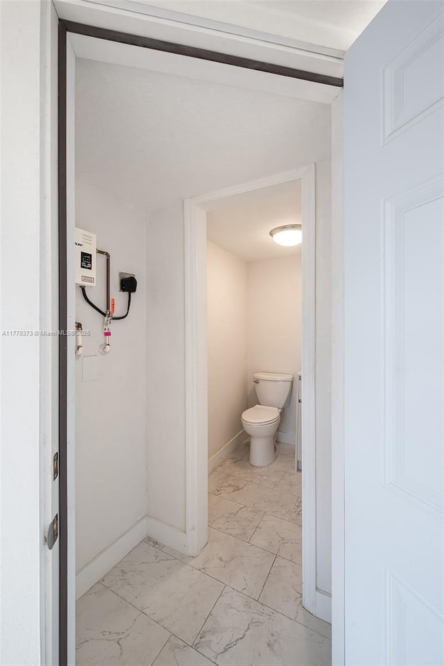 411 NE 58th Ct, Oakland Park, FL 33334 - bathroom with toilet, marble finish floor, and baseboards