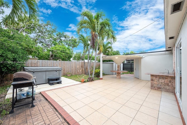 411 NE 58th Ct, Oakland Park, FL 33334 - view of patio / terrace featuring a grill, a hot tub, visible vents, and a fenced backyard