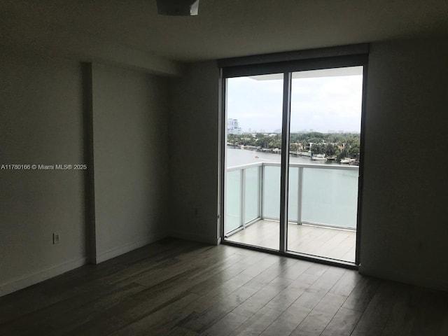 spare room featuring wood finished floors and baseboards