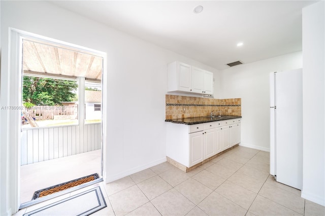5715 Garfield St, Hollywood, FL 33021 - kitchen with tasteful backsplash, visible vents, freestanding refrigerator, white cabinetry, and light tile patterned flooring
