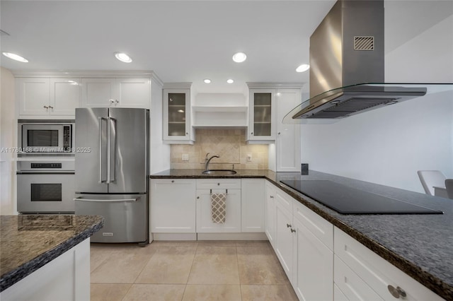 kitchen featuring stainless steel appliances, island exhaust hood, a sink, white cabinetry, and light tile patterned floors