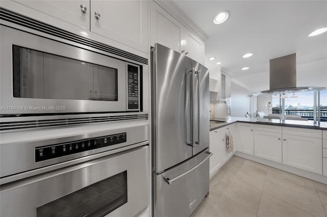 kitchen with white cabinets, recessed lighting, island range hood, appliances with stainless steel finishes, and light tile patterned floors