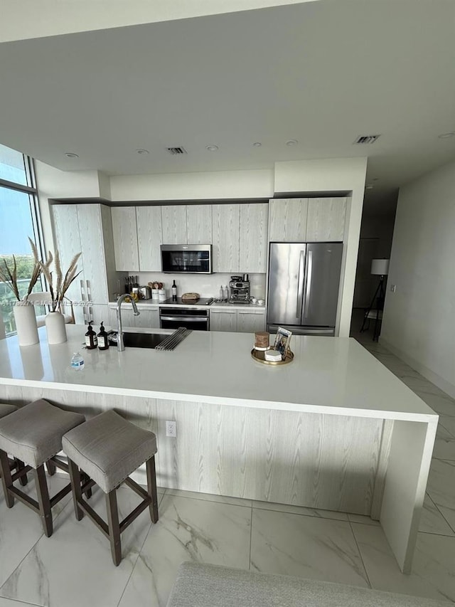2000 Metropica Way Unit 603, Sunrise, FL 33323 - kitchen with appliances with stainless steel finishes, light marble finish flooring, and modern cabinets