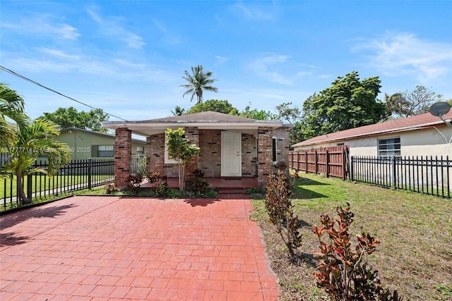 721 NW 6th St, Hallandale Beach, FL 33009 - bungalow featuring brick siding, a porch, fence, and a front lawn