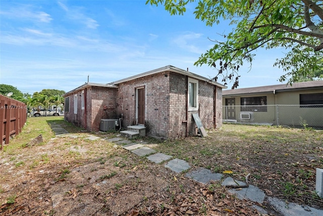 721 NW 6th St, Hallandale Beach, FL 33009 - back of property featuring brick siding, fence, and cooling unit