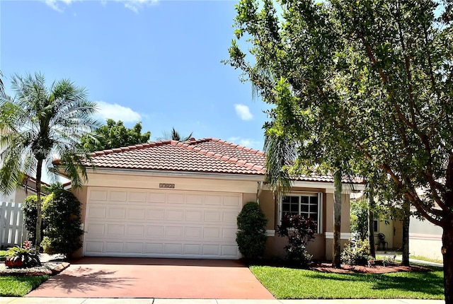 mediterranean / spanish-style home with stucco siding, a tiled roof, an attached garage, and concrete driveway