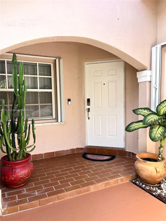 entrance to property featuring stucco siding