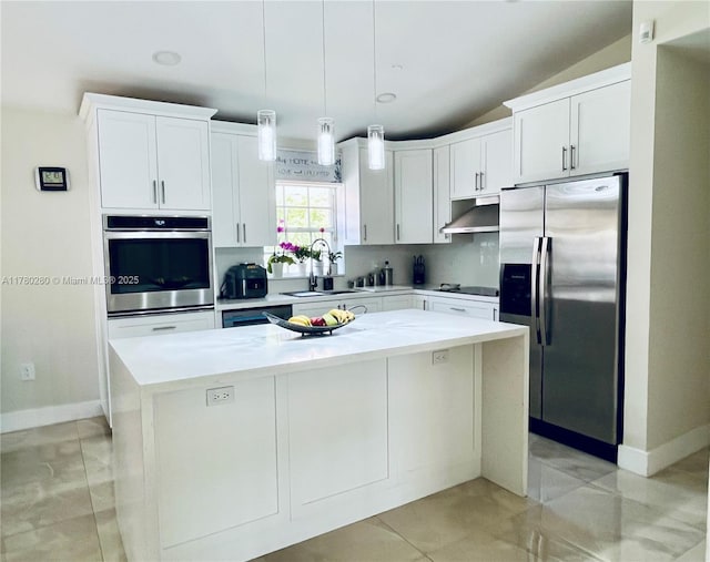 kitchen featuring a sink, stainless steel appliances, under cabinet range hood, white cabinetry, and a kitchen island