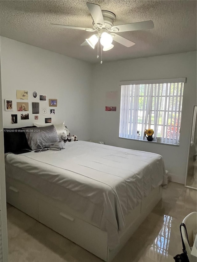 bedroom with a ceiling fan and a textured ceiling
