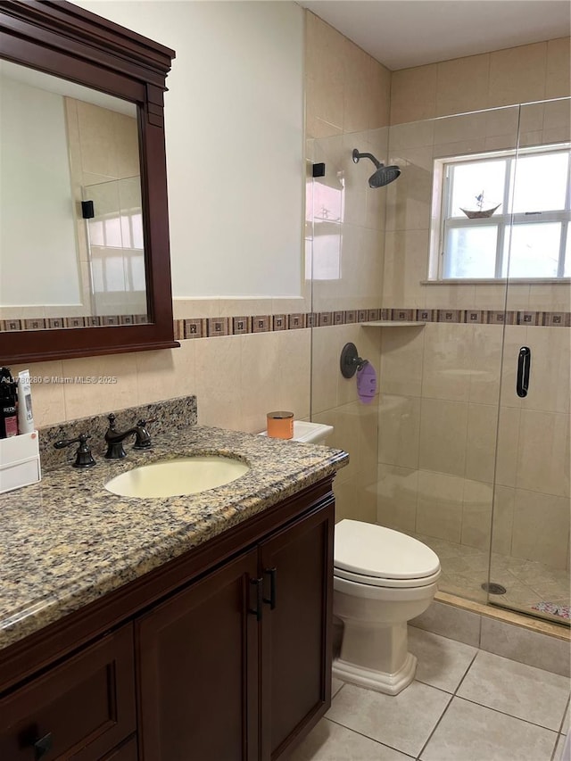 full bath featuring a stall shower, toilet, tile walls, tile patterned floors, and vanity