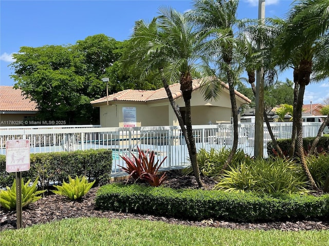 view of home's exterior featuring a pool, fence, stucco siding, and a tiled roof