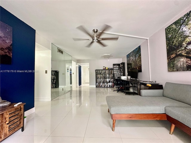 living area featuring visible vents, baseboards, a ceiling fan, and tile patterned flooring