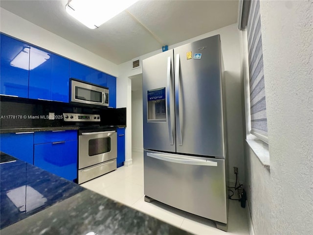 kitchen with visible vents, light tile patterned floors, modern cabinets, stainless steel appliances, and blue cabinets