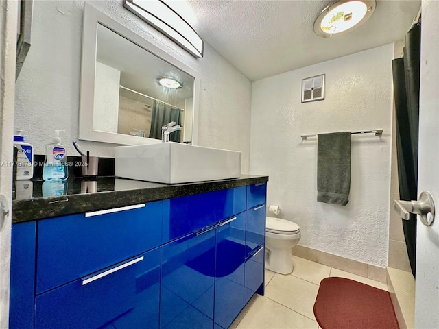 full bath featuring a textured ceiling, a textured wall, and tile patterned flooring