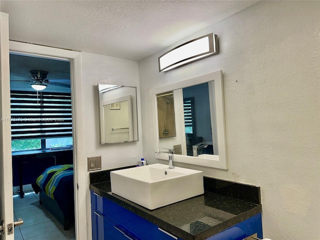bathroom with a textured wall, vanity, and a textured ceiling