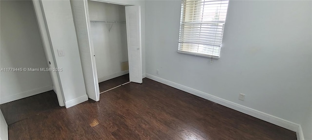 unfurnished bedroom featuring wood finished floors, a closet, and baseboards