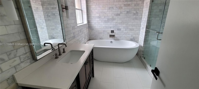 full bath featuring a stall shower, a freestanding tub, vanity, and tile walls
