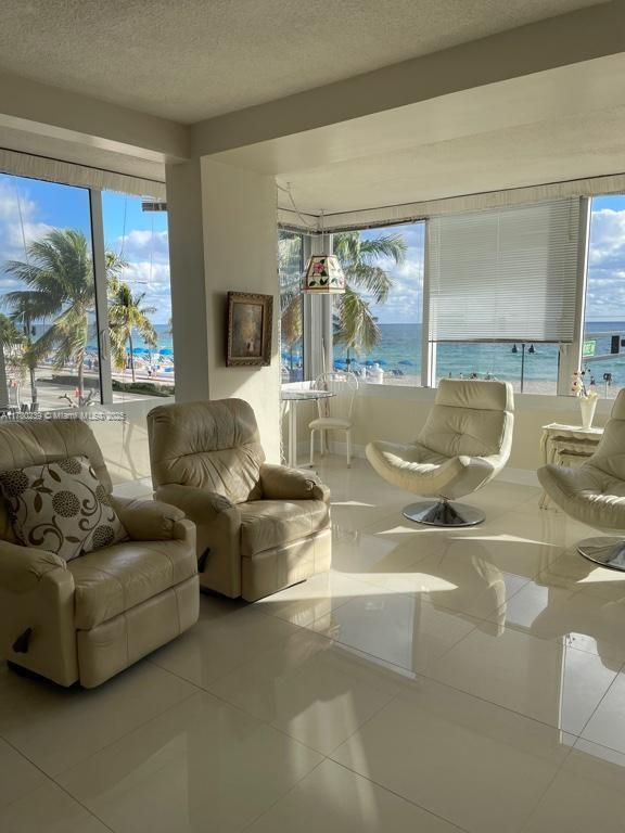 345 N Fort Lauderdale Beach Blvd Unit 202, Fort Lauderdale, FL 33304 - sitting room with tile patterned floors, a textured ceiling, and a healthy amount of sunlight