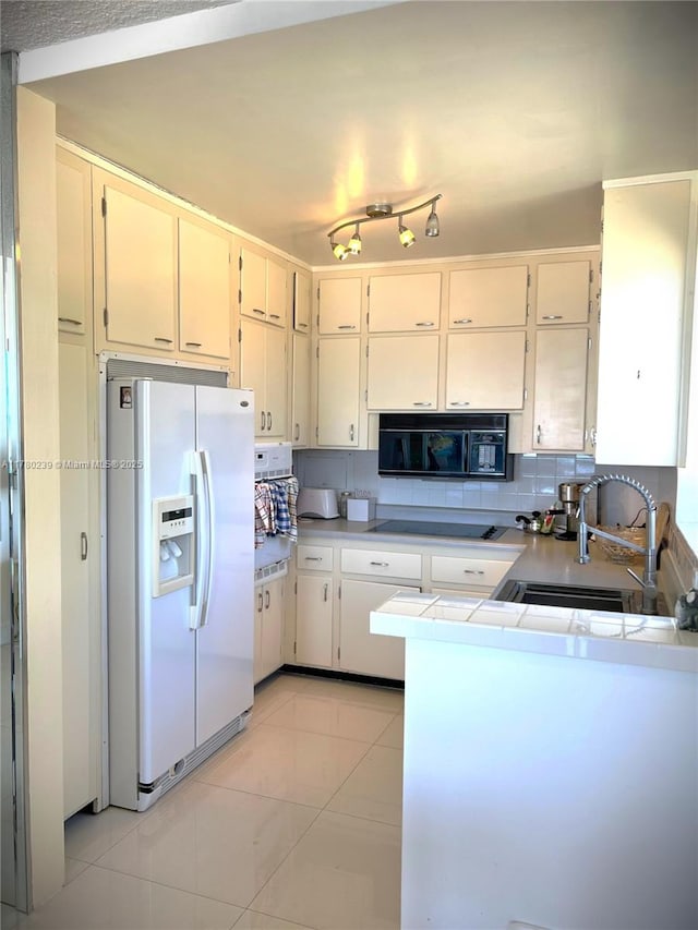 345 N Fort Lauderdale Beach Blvd Unit 202, Fort Lauderdale, FL 33304 - kitchen featuring black appliances, cream cabinetry, light tile patterned flooring, light countertops, and a sink