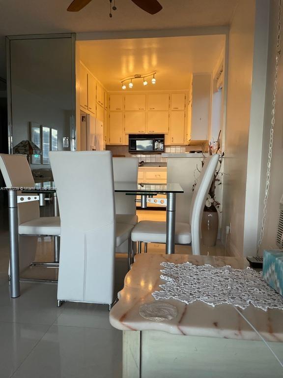 345 N Fort Lauderdale Beach Blvd Unit 202, Fort Lauderdale, FL 33304 - kitchen featuring tile patterned floors, black microwave, tasteful backsplash, and ceiling fan